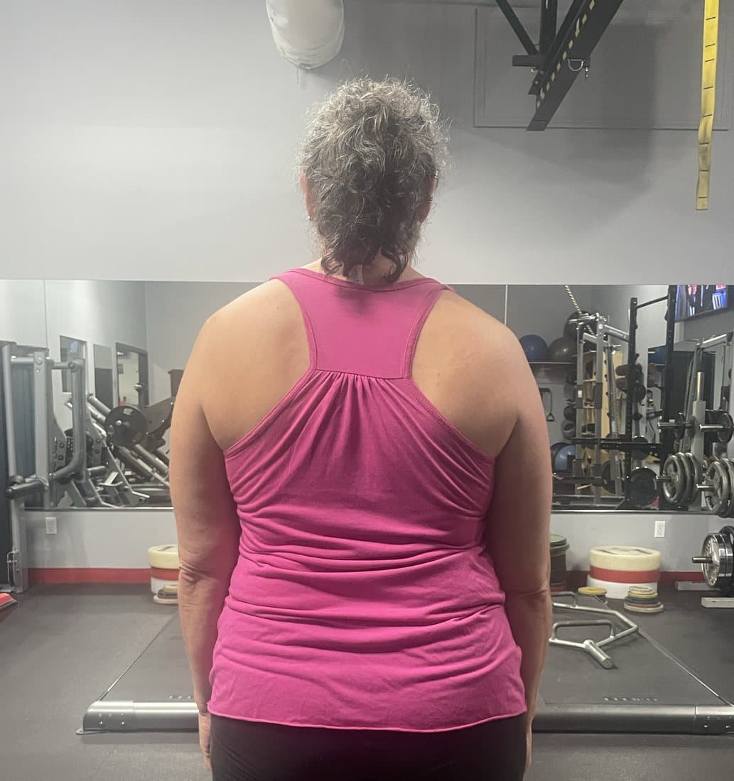 A client standing for a posture assessment at the start of training